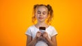 Cute schoolgirl enjoying taste of delicious chocolate, happy childhood, emotions