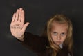 Cute schoolgirl scared sad asking for help showing hands with stop bullying text written on her palm