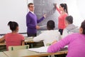 Cute schoolgirl solves task near blackboard in classroom mathematics Royalty Free Stock Photo