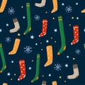 Cute seamless pattern on winter time. Knitted socks and snowflakes on a dark background. Vector illustration.