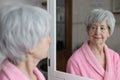 Cute senior woman looking at her reflection in the bathroom Royalty Free Stock Photo