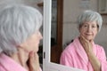 Cute senior woman looking at her reflection in the bathroom Royalty Free Stock Photo