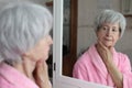 Cute senior woman looking at her reflection in the bathroom Royalty Free Stock Photo