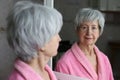 Cute senior woman looking at her reflection in the bathroom Royalty Free Stock Photo