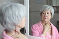 Cute senior woman looking at her reflection in the bathroom Royalty Free Stock Photo