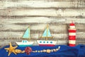 set of kids handcrafted boats, fish, nautical attributes and more on rough vintage wooden background top view Royalty Free Stock Photo