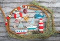set of kids handcrafted boats, fish, nautical attributes and more on rough vintage wooden background top view