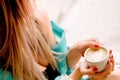 Cute sexy blonde holds a cup of coffee. beautiful woman sits on a windowsill and enjoys a delicious drink, morning ritual Royalty Free Stock Photo