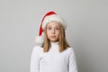 Cute shocked surprised child girl in Santa hat looking at camera on white background Royalty Free Stock Photo