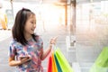 Cute shopping girl holding shopping bags,pointing finger to shop Royalty Free Stock Photo