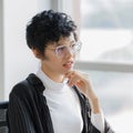 Cute and short hair businesswoman wearing eyesglasses in office