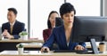 Cute short hair businesswoman working in offce with her colleagues sitting blur in background
