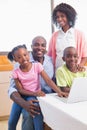 Cute siblings using laptop together with parents Royalty Free Stock Photo
