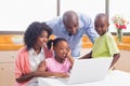 Cute siblings using laptop together with parents Royalty Free Stock Photo
