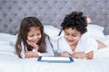 Cute siblings using tablet on the bed