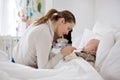 Cute sick child, baby boy, staying in bed, mom giving him medici Royalty Free Stock Photo