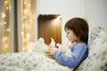 Cute sick child, boy, staying in bed, playing with teddy bear Royalty Free Stock Photo