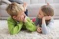 Cute silblings smiling at each other on rug Royalty Free Stock Photo