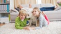 Cute silblings with their puppy on rug Royalty Free Stock Photo