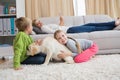 Cute silblings with their puppy on rug Royalty Free Stock Photo