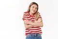 Cute silly asian girl blond haircut wearing summer striped t-shirt shrugging cute smiling cross arms chest feel chilly Royalty Free Stock Photo