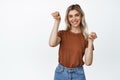 Cute silly girl smiles, shows cat paws gesture, standing in t-shirt and jeans against white background Royalty Free Stock Photo