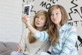 Cute sisters pouting while taking photos with smart phone at home Royalty Free Stock Photo