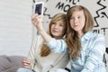 Cute sisters taking photos with smart phone at home Royalty Free Stock Photo