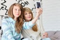 Cute sisters taking photos with smart phone at home Royalty Free Stock Photo