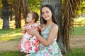 Cute sisters teen and baby girl playing on green grass Royalty Free Stock Photo