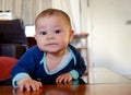 Cute six months old baby boy drooling on the flor and making funny faces Royalty Free Stock Photo