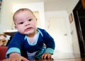 Cute six months old baby boy drooling on the flor and making funny faces Royalty Free Stock Photo