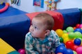 Cute six months old baby boy playing with colorful balls in the childcare Royalty Free Stock Photo