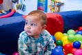 Cute six months old baby boy playing with colorful balls in the childcare Royalty Free Stock Photo