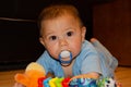 Cute six months old baby boy playing on the flor with teething toy, early development and teething concept Royalty Free Stock Photo