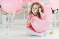 Cute six year old girl in pink dress with pink balloons in the shape of heart Royalty Free Stock Photo