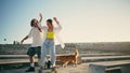 Cute skaters learning skateboard tricks street. Couple having fun riding skate Royalty Free Stock Photo