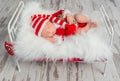 Cute sleeping baby in red hat on little bed Royalty Free Stock Photo