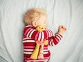 Cute sleeping blond baby with toy