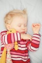 Cute sleeping blond baby with toy