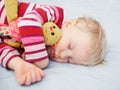 Cute sleeping blond baby with toy