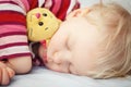 Cute sleeping blond baby with toy