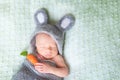 Cute sleeping newborn baby dressed like Easter bunny