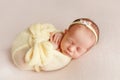 Cute sleeping newborn girl with a bandage on her head wrapped in Royalty Free Stock Photo