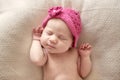 Cute sleeping newborn girl in pink hat, close-up Royalty Free Stock Photo