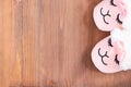 Cute sleeping pink lama trendy slippers soft pastel colours pink on brown wooden textured background Top view Soft