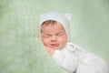 Cute sleeping newborn baby in white knitted fluffy kitten costume Royalty Free Stock Photo