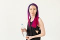 Cute slender young asian woman with colored hair drinking water after gym workout. Concept of replenishing water balance Royalty Free Stock Photo