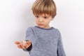 Cute small boy holding hearing aids on his palm. Focused on the hearing aid Royalty Free Stock Photo