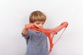 Cute small boy playing with slime looks like red gunk squeezing it between his hands